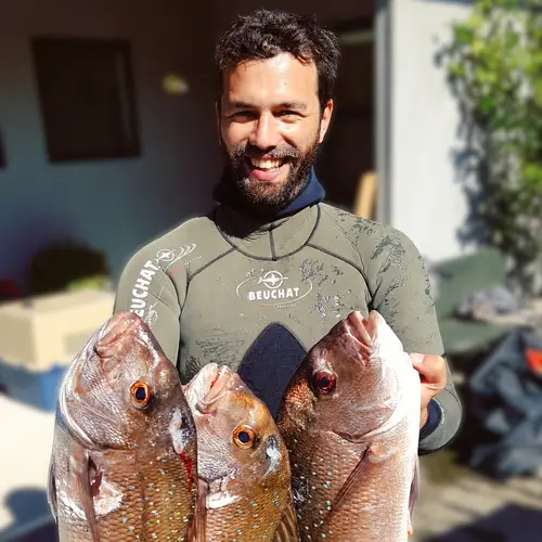 Dr Darcy Webber holding three fish